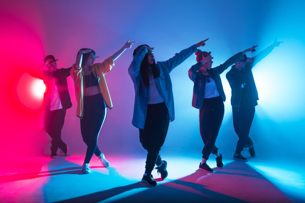 group,of,male,and,female,dancers,in,colorful,neon,light