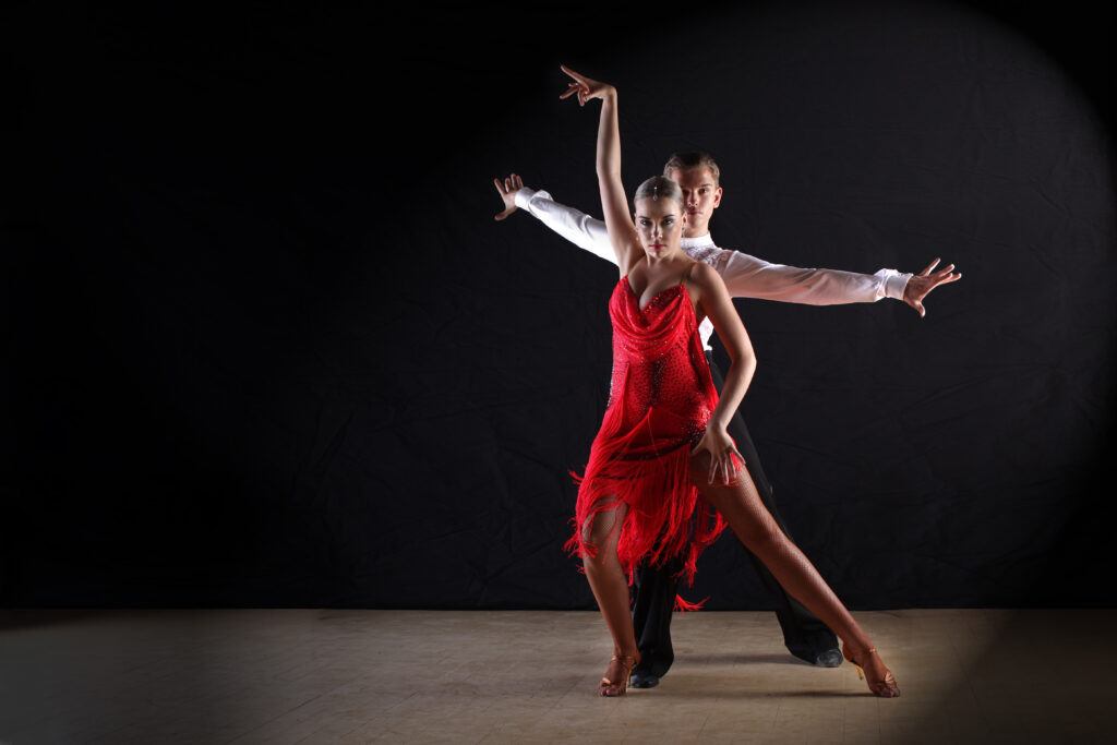 latino,dancers,in,ballroom,against,black,background